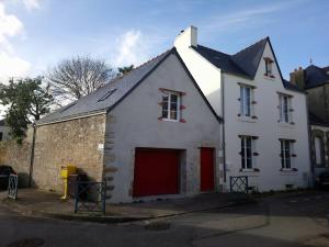 un bâtiment blanc avec une porte rouge dans une rue dans l'établissement Appartement Studio Chanoine, à Quimper