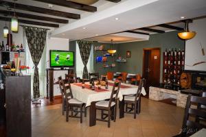 a dining room with a table and chairs and a television at Franzdorf Alpin in Văliug