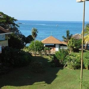 a view of a house with the ocean in the background at Point Village Negril in Negril