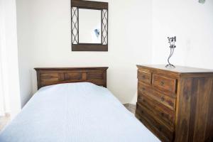 a bedroom with a bed and a dresser and a mirror at Captain John Houses Caldera Oia in Oia
