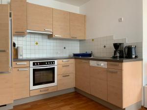 a kitchen with wooden cabinets and a stove top oven at Haus Helga in Lienz