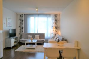 a living room with a couch and a table at Galaxy Apartments Airport in Vantaa
