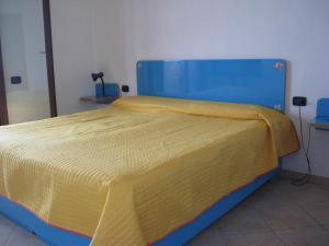 a blue and yellow bed with a yellow blanket on it at Casa Porto Corallo in Villaputzu +17 photos