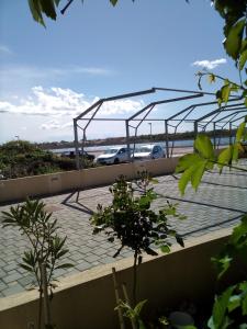 a car parked in a parking lot with a metal structure at Apartman Edi in Nin