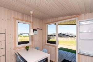 a dining room with a table and two windows at Hirtshals Camping in Hirtshals