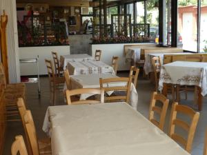 un restaurante con mesas y sillas con mesas blancas en Dallapia en Santa Maria del Piano