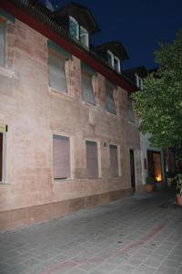 a large brick building with shuttered windows at night at Belle Vue Apartrooms in Fürth