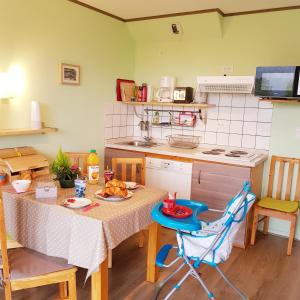 a kitchen with a table and a table and chairs at APPT 3* LE HAUT DES LACS in Xonrupt-Longemer