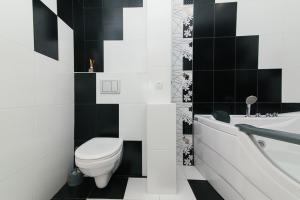 ein schwarz-weißes Bad mit einem WC und einer Badewanne in der Unterkunft 14/3 вулиця Прокоф'єва in Sumy