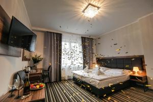 a bedroom with a bed and a table and a television at New Corner in Niechorze