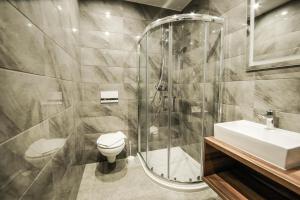 a bathroom with a shower and a toilet and a sink at New Corner in Niechorze +67 photos