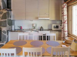 een keuken met een houten tafel en witte stoelen bij Holiday Home Lomaylläs a 13 - hotellintie 1 a by Interhome in Ylläsjärvi