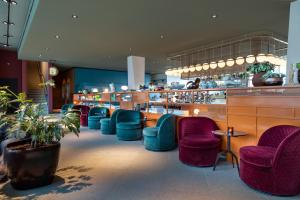 a restaurant with purple chairs and a bar at Olympic Hotel in Amsterdam