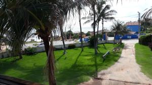 un parc verdoyant avec des palmiers et un sentier dans l'établissement Pousada Via Lactea, à Canoa Quebrada