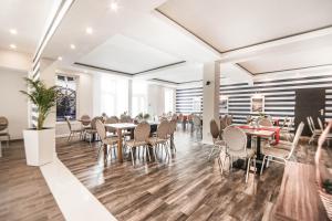 um restaurante com mesas e cadeiras numa cafetaria em New Corner em Niechorze