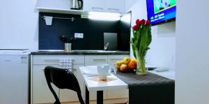 a kitchen with a table with a vase of red tulips and a v at Pula Center Apartments and Rooms in Pula