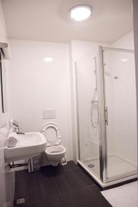 a bathroom with a shower, sink, and toilet at St Christophers Inn at The Winston in Amsterdam