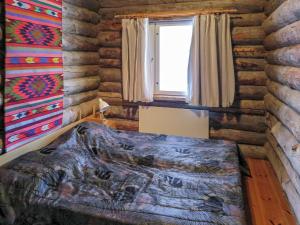 een slaapkamer met een bed in een blokhut bij Holiday Home Lomaylläs a 13 - hotellintie 1 a by Interhome in Ylläsjärvi