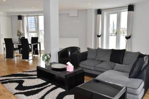 ein Wohnzimmer mit einem Sofa und einem Tisch in der Unterkunft Luxlogic in London