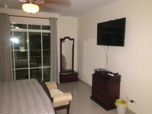 a bedroom with a bed and a mirror and a television at Stone Creek Barranquilla in Barranquilla