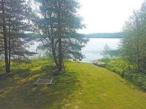 KinnulaにあるHoliday Home Mäntyranta by Interhomeの湖の横の畑の木と船
