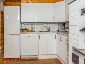 cocina con electrodomésticos blancos y pared de ladrillo en Holiday Home Kaaposniemi by Interhome, en Miehoila