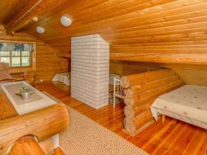 Cabaña de madera con cama y chimenea en Holiday Home Kaaposniemi by Interhome, en Miehoila