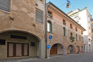 a brick building with arches on a street at Apartment Deluxe Isola Di Mezzo in Treviso