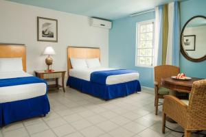 
a hotel room with two beds and a desk at Deja Resort All Inclusive in Montego Bay
