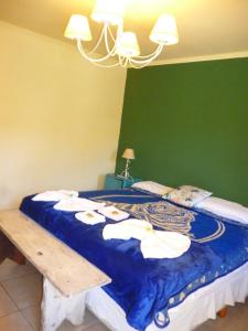 a bedroom with a bed with a blue blanket at Passaros Suite Hotel in Puerto Iguazú