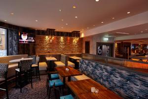 a restaurant with tables and chairs and a bar at Royal Hotel in Cumnock