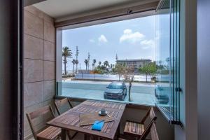 a balcony with a table and chairs and a view of a car at ApartUP Patacona Beach Select in Valencia