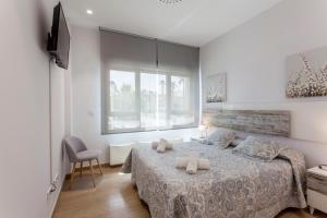 a bedroom with a large bed and a window at ApartUP Patacona Beach Select in Valencia +40 photos