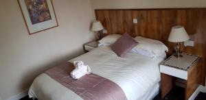 a bedroom with a bed with a teddy bear on it at Dalgair House Hotel in Callander