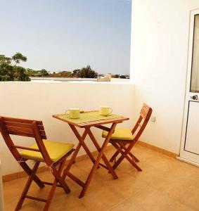 a wooden table and two chairs sitting on a balcony at Martin House - Montenegro - FARO - ALGARVE in Faro