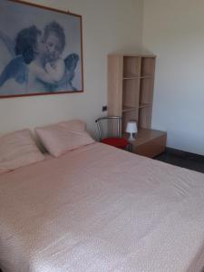 ein Schlafzimmer mit einem Bett mit einem Bild an der Wand in der Unterkunft tavernetta vista lago in Verbania