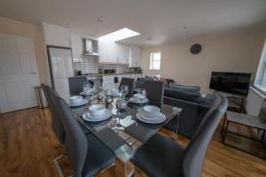 a dining table and chairs in a living room at The Coach House - London Heathrow Serviced Apartments in Stanwell