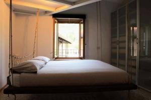 een slaapkamer met een schommelbed en een raam bij La casa di Sabrina in Arco
