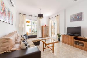 uma sala de estar com um sofá e uma televisão de ecrã plano em Villa Oliva Nerja - Private Pool - heated by Solar Panels em Nerja