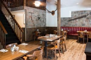 ein Restaurant mit Holztischen und einem roten Sofa in der Unterkunft Trapper's Choice Inn & Restaurant in Parry Sound