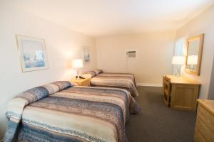 een hotelkamer met 2 bedden en 2 lampen bij Trapper's Choice Inn & Restaurant in Parry Sound