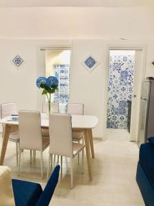 una sala da pranzo con tavolo e sedie con piastrelle bianche e blu di Penisola Home Experience a Vico Equense