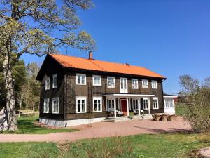 uma grande casa de madeira com um telhado laranja em Björnhofvda Gård em Björnhuvud