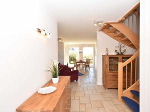 un salon avec un escalier et une salle à manger dans l'établissement Ferienhaus Boddenbrise mit Hiddenseeblick, à Vieregge