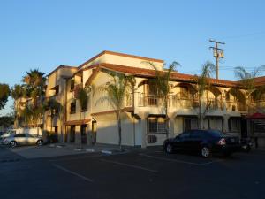 un gran edificio con coches estacionados en un estacionamiento en Best Inn & Suites en Anaheim