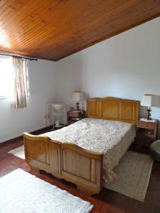 a bedroom with a large wooden bed in a room at Casa dos Pocinhos - Férias tranquilas no campo in Torres Novas