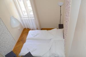 uma pequena cama num quarto com uma janela em Synagogue Central Guest House em Budapeste