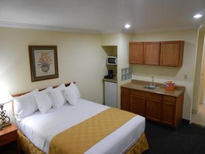 a hotel room with a bed and a kitchen at Best Inn & Suites in Anaheim