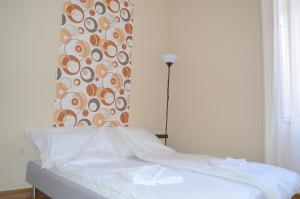 uma cama num quarto com uma parede estampada em Synagogue Central Guest House em Budapeste