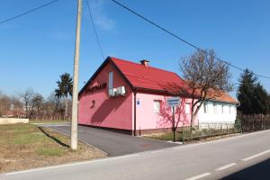 a red and white building on the side of a road at Apartman Kupa in Karlovac